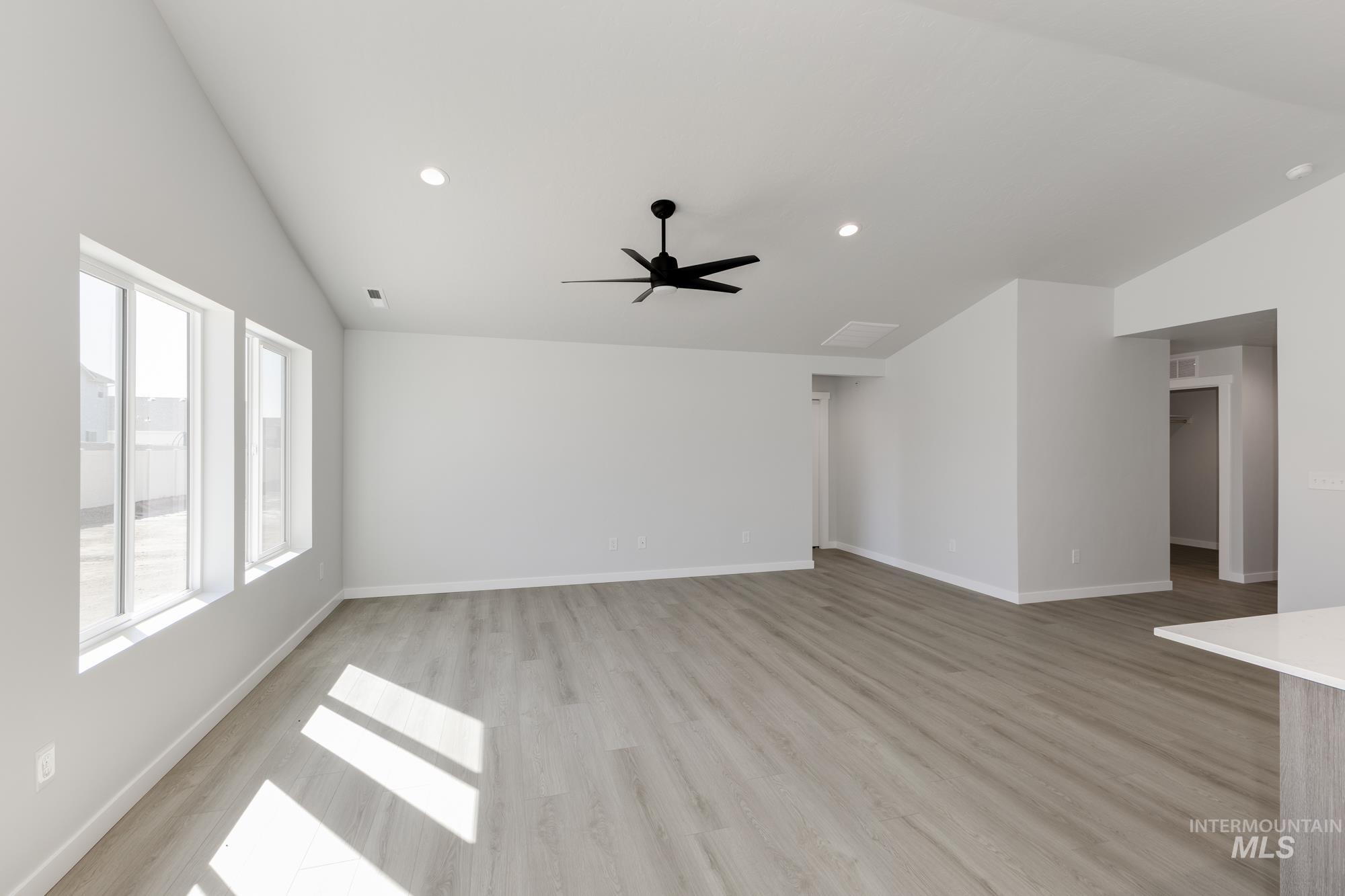 Unfurnished living room featuring lofted ceiling, recessed lighting, light wood-style floors, and a ceiling fan