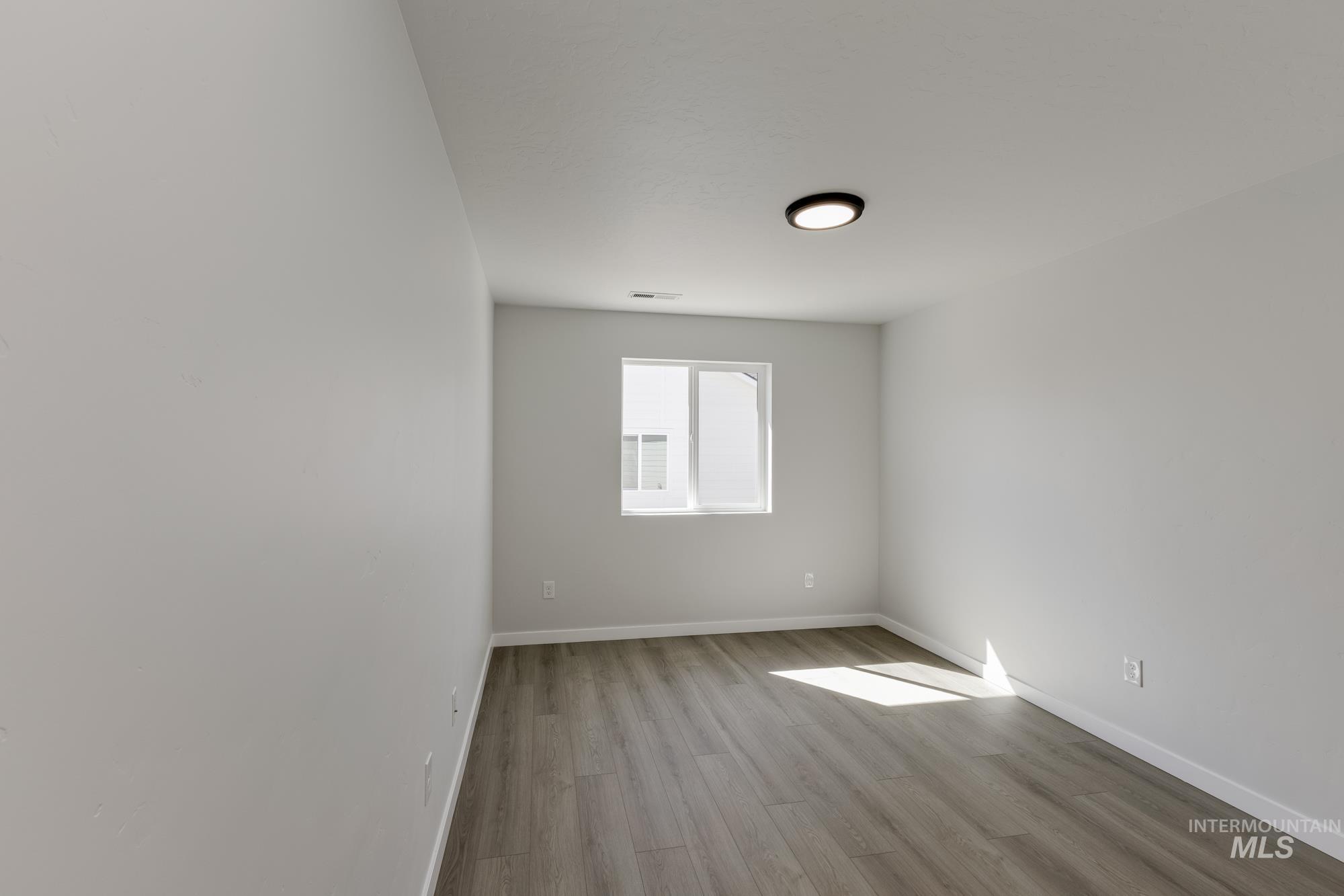 Spare room featuring baseboards and light wood-style flooring