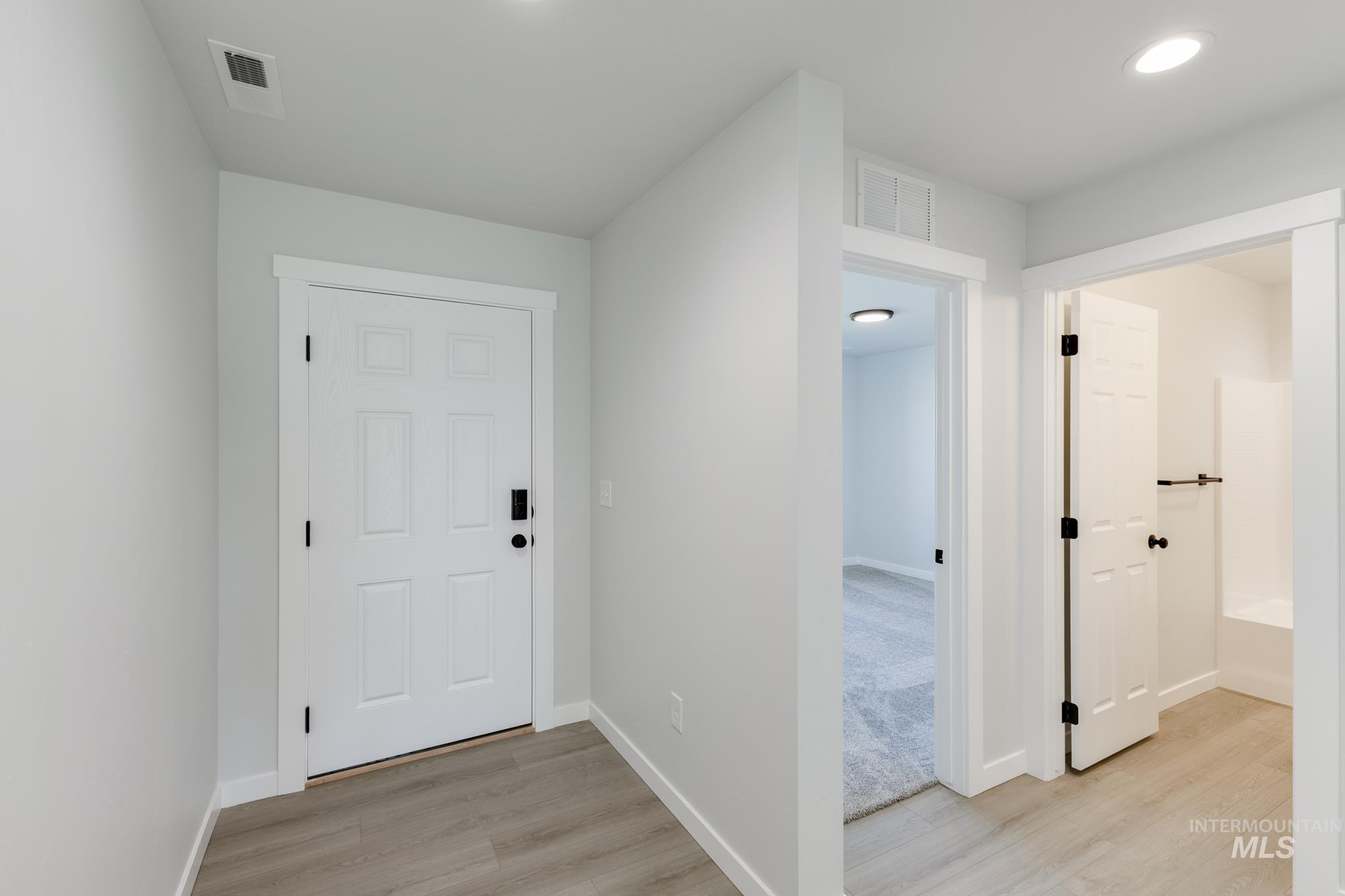 Corridor with light wood-style floors and baseboards