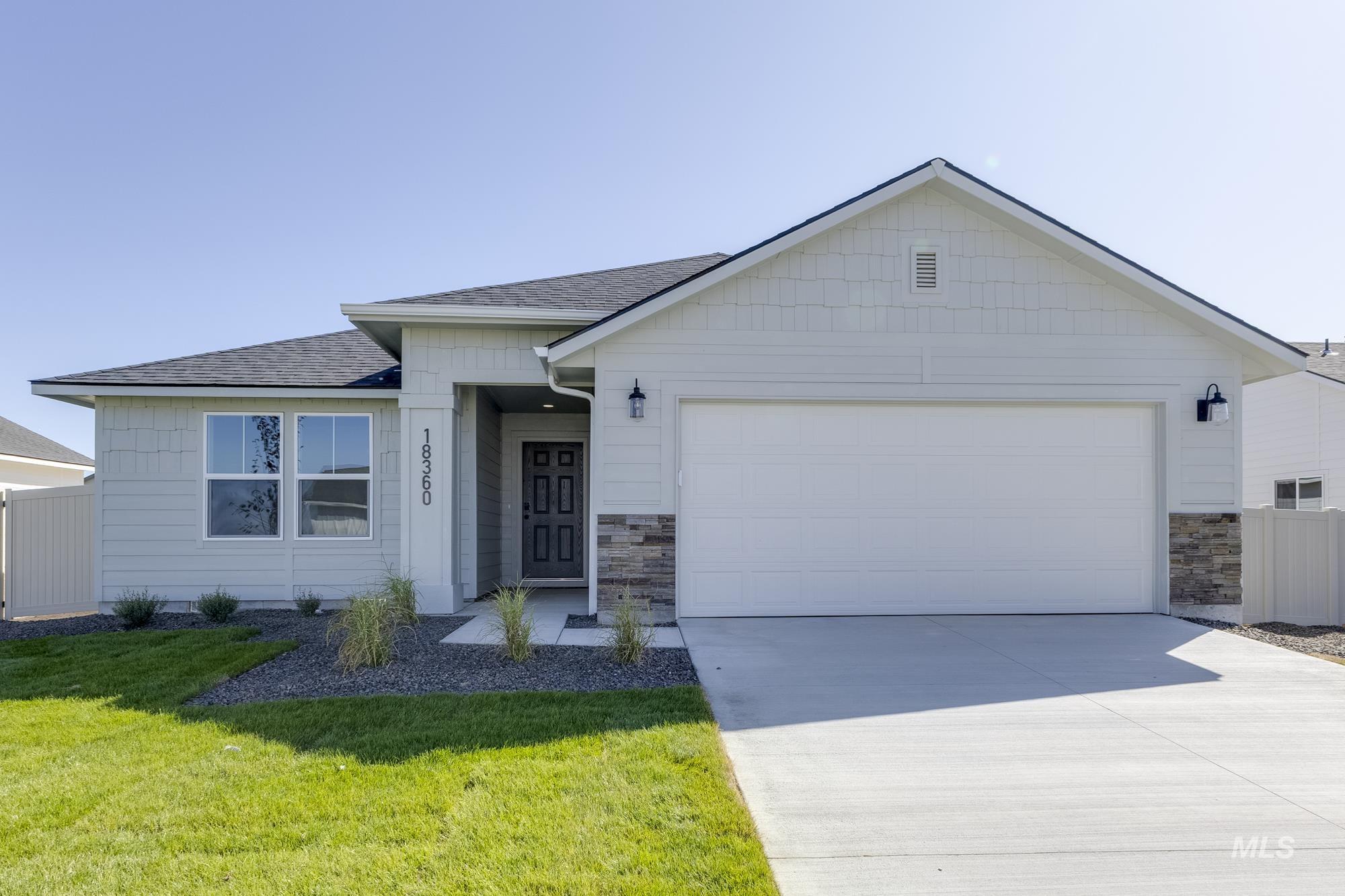 Single story home featuring stone siding, roof with shingles, driveway, and a garage
