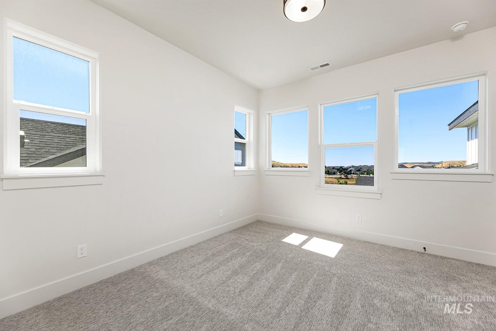 Carpeted spare room with baseboards
