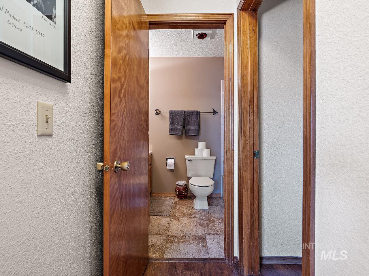 Bathroom featuring toilet and stone finish floors