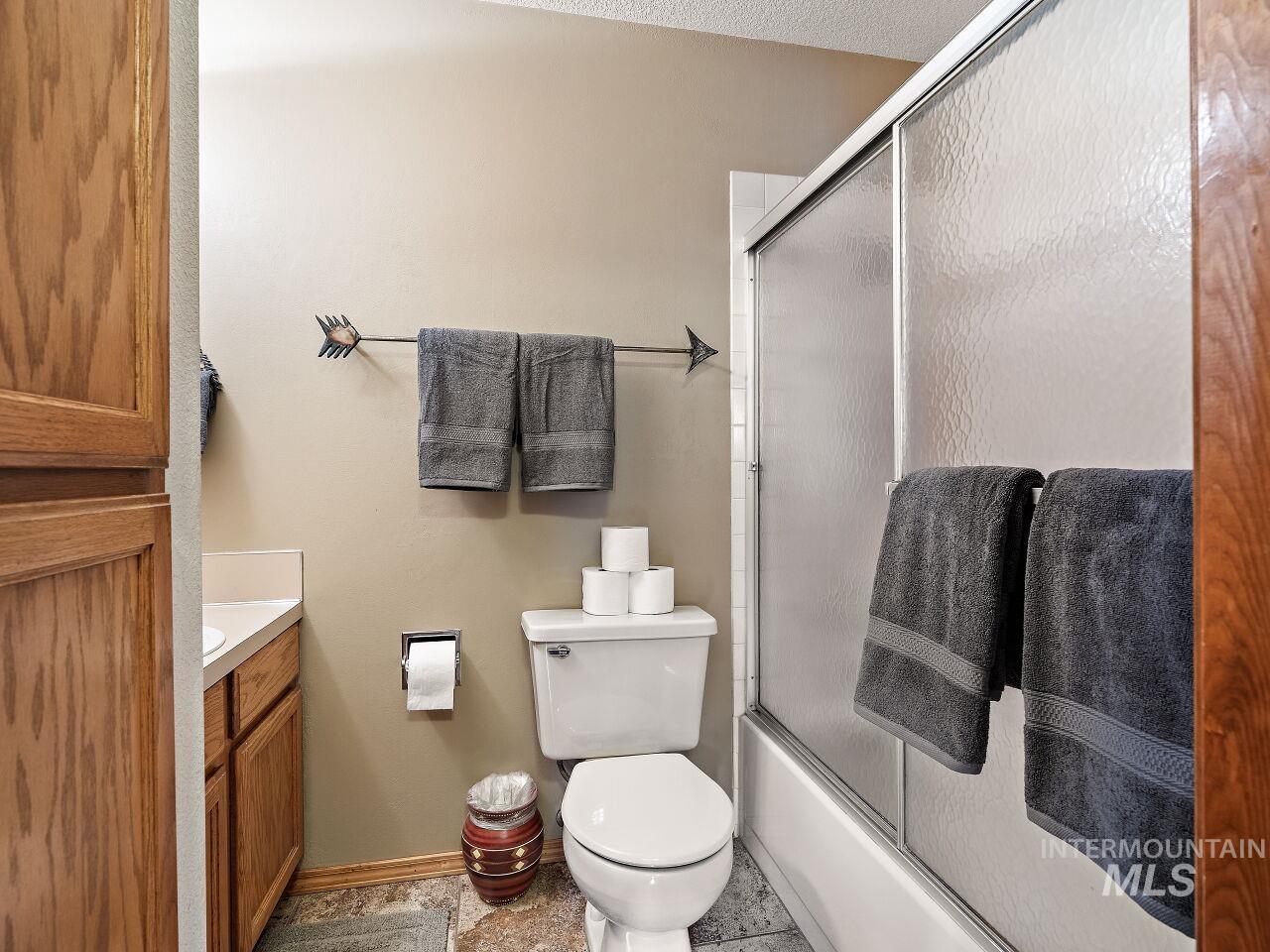 Bathroom with vanity and enclosed tub / shower combo