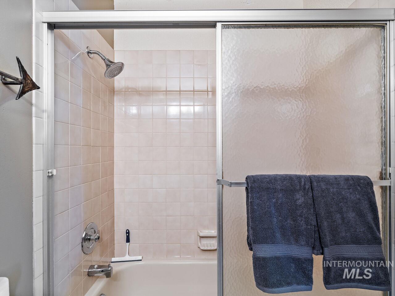 Bathroom featuring bath / shower combo with glass door