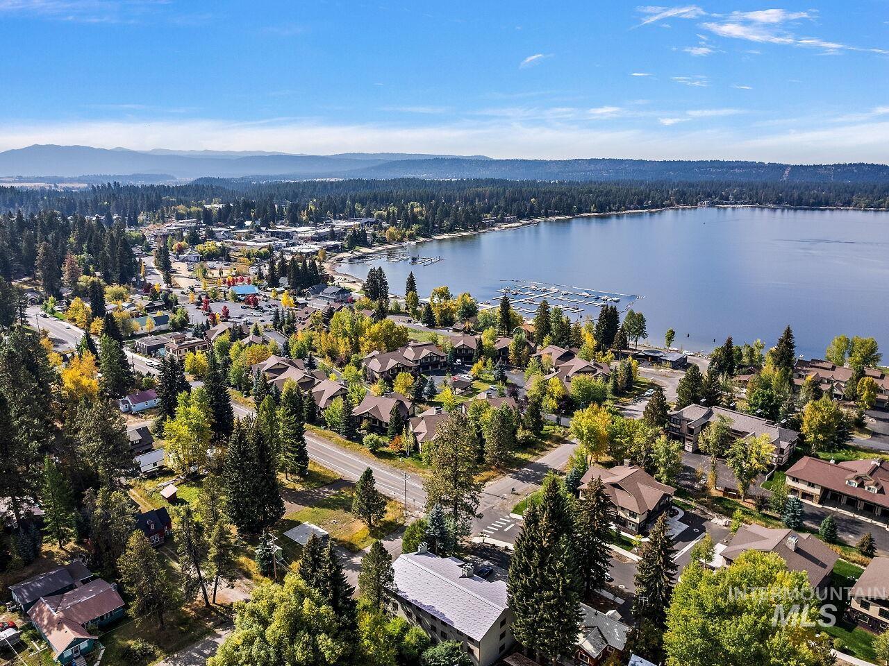 Aerial view of property and surrounding area with a water and mountain view and nearby suburban area