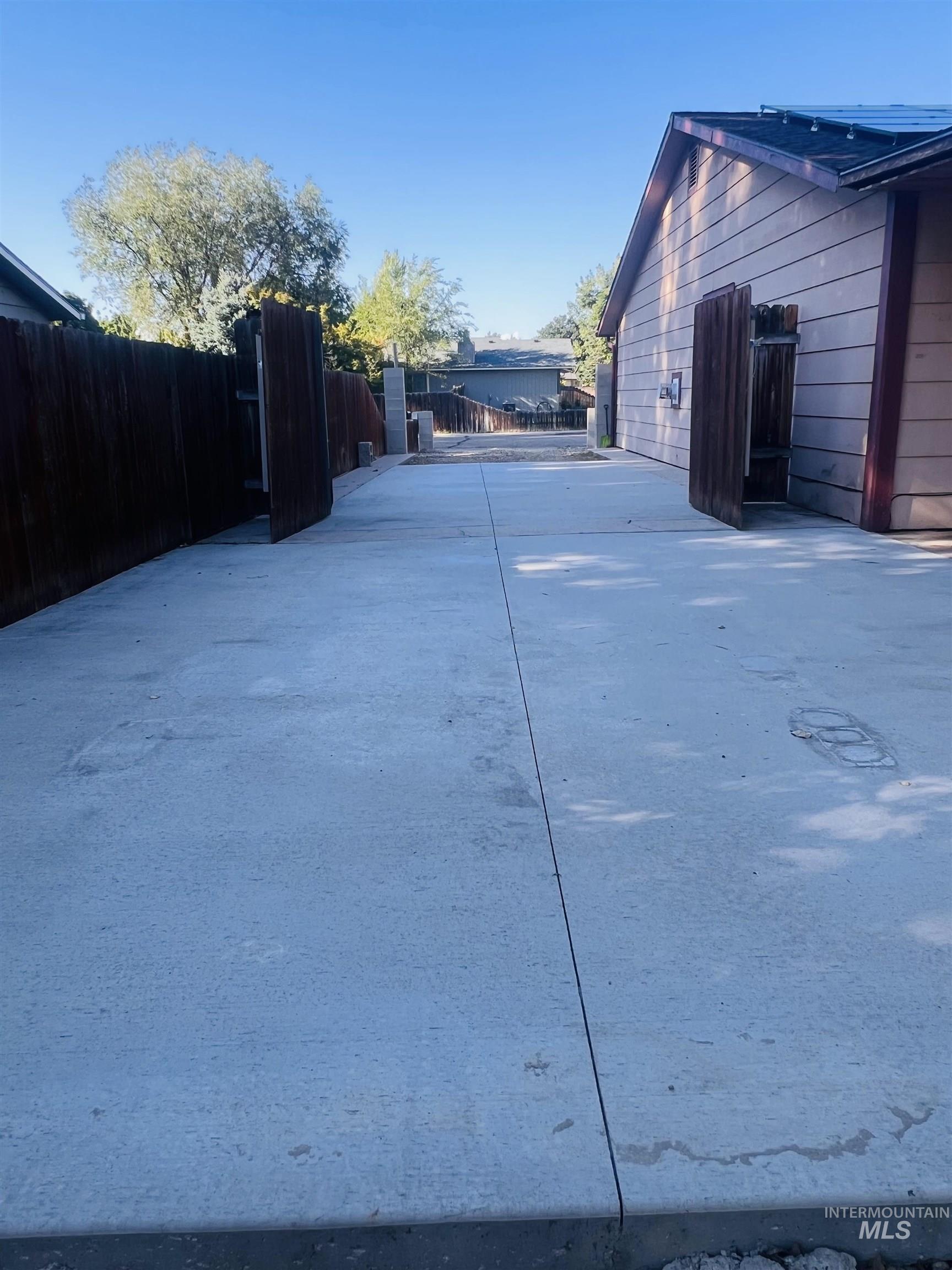 Expansive concrete driveway providing vehicle access to the property
