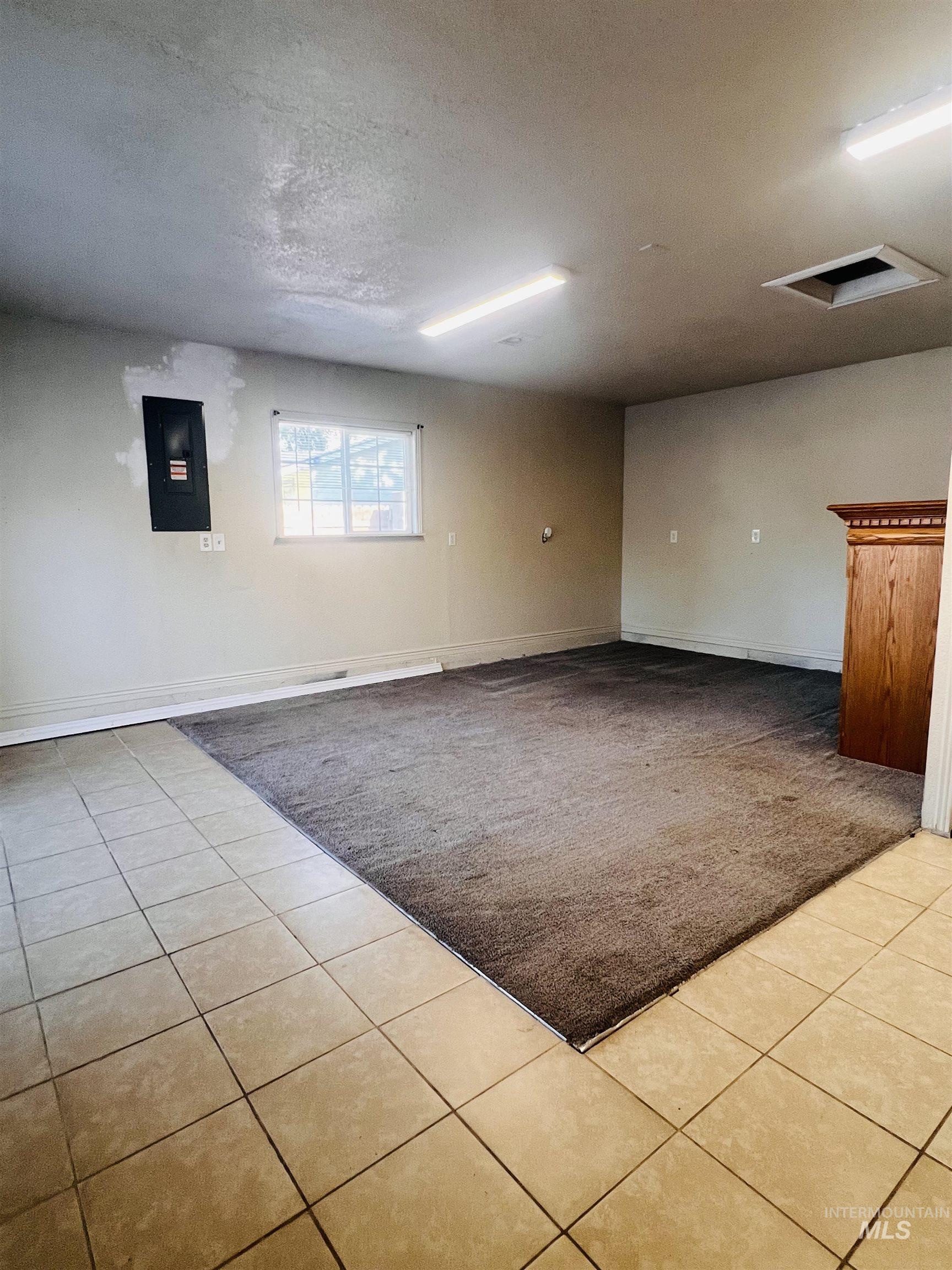 Spacious room featuring partial tile flooring, partial carpet, and a window for natural light.  Bring your ideas...family room conversion.