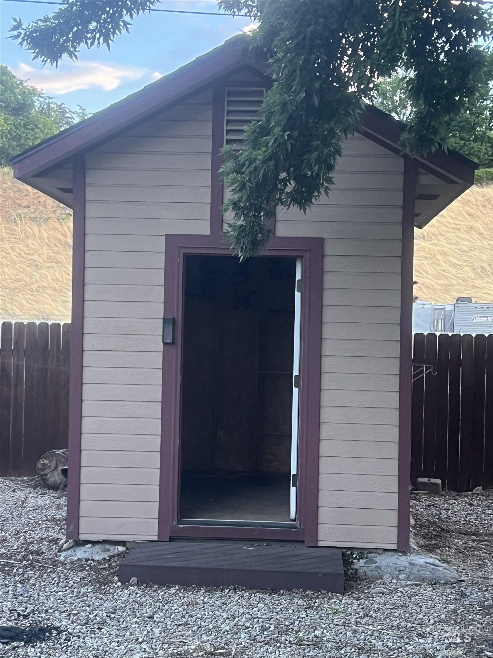 Freestanding utility shed with horizontal siding and contrasting trim