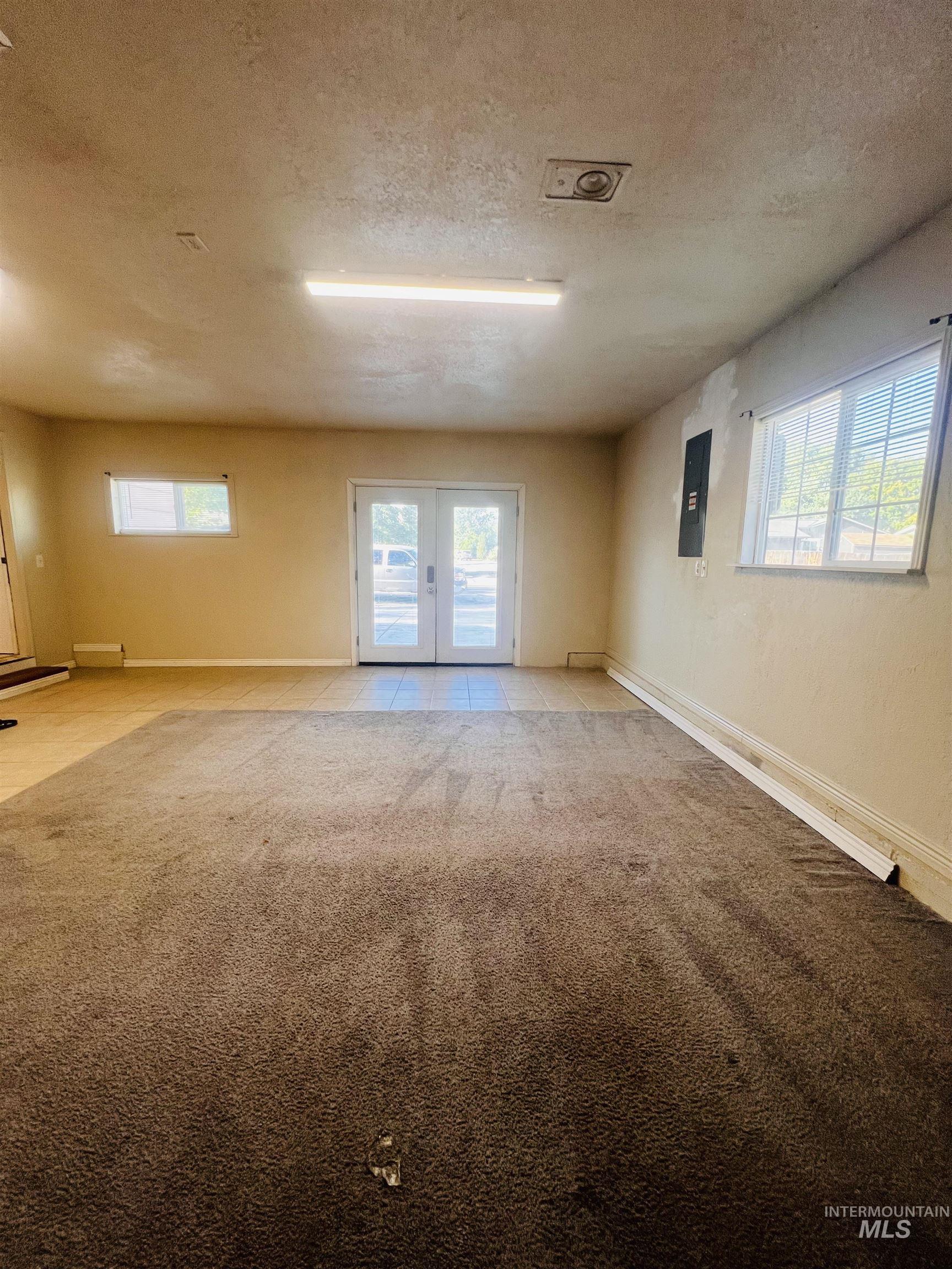 Spacious interior featuring a combination of carpet and tiled flooring