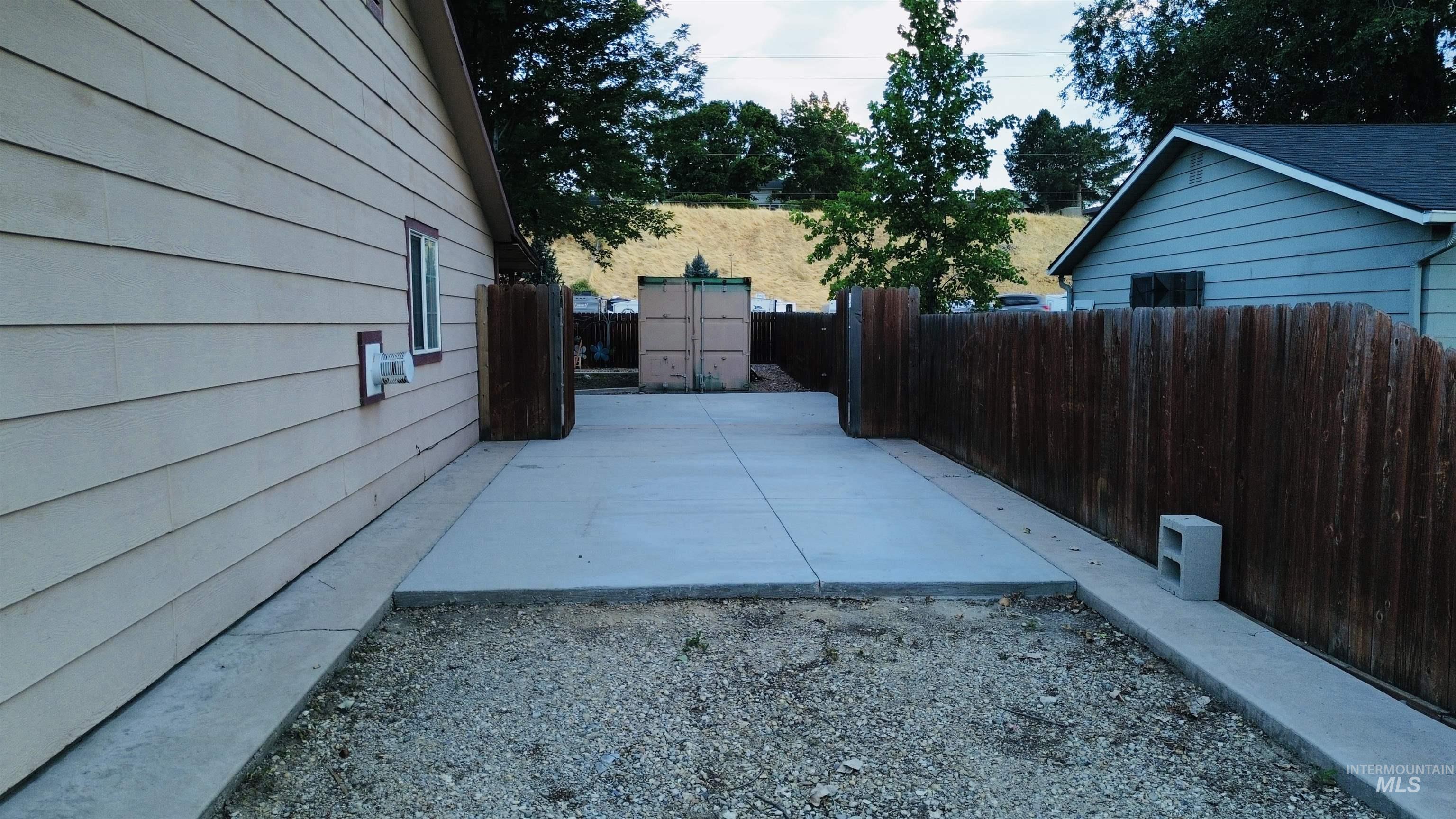 Spacious concrete patio with surrounding gravel area