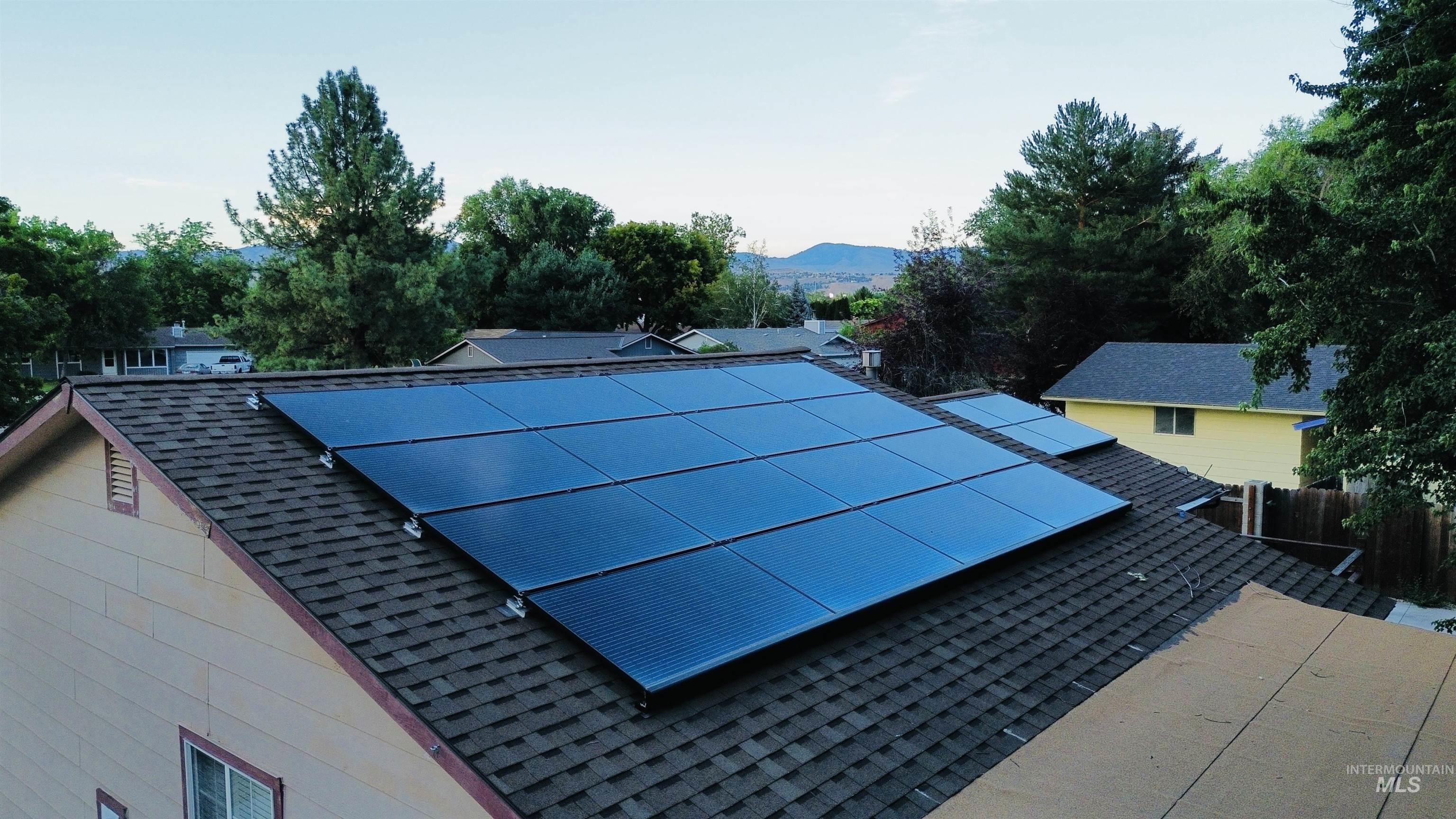 Extensive rooftop solar panel array installed on a shingle roof.  Owned and placed 1/2 of front and full back.