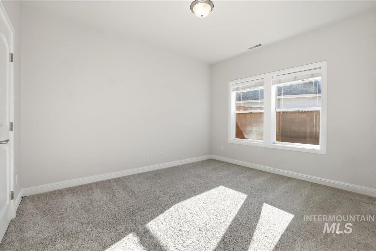 Unfurnished room featuring light carpet and baseboards