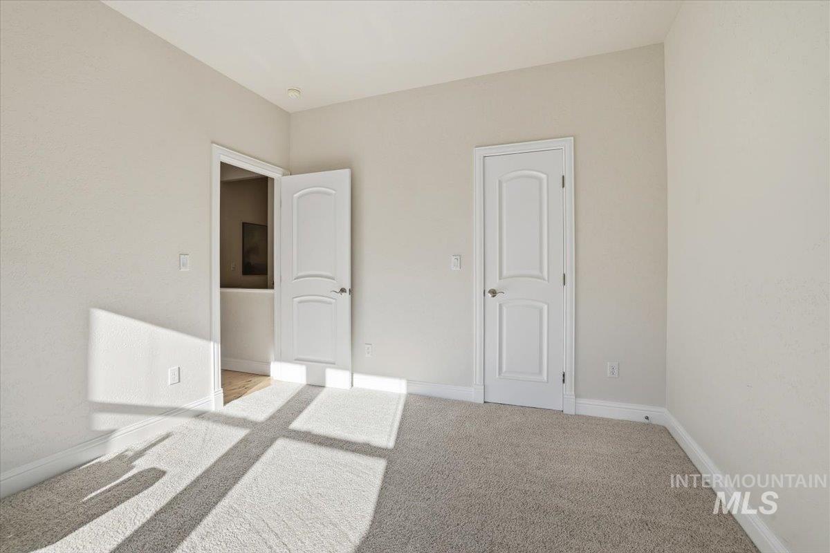 Unfurnished bedroom with carpet and baseboards