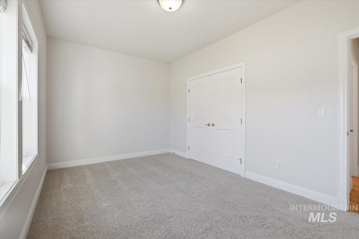 Unfurnished bedroom featuring light colored carpet and a closet