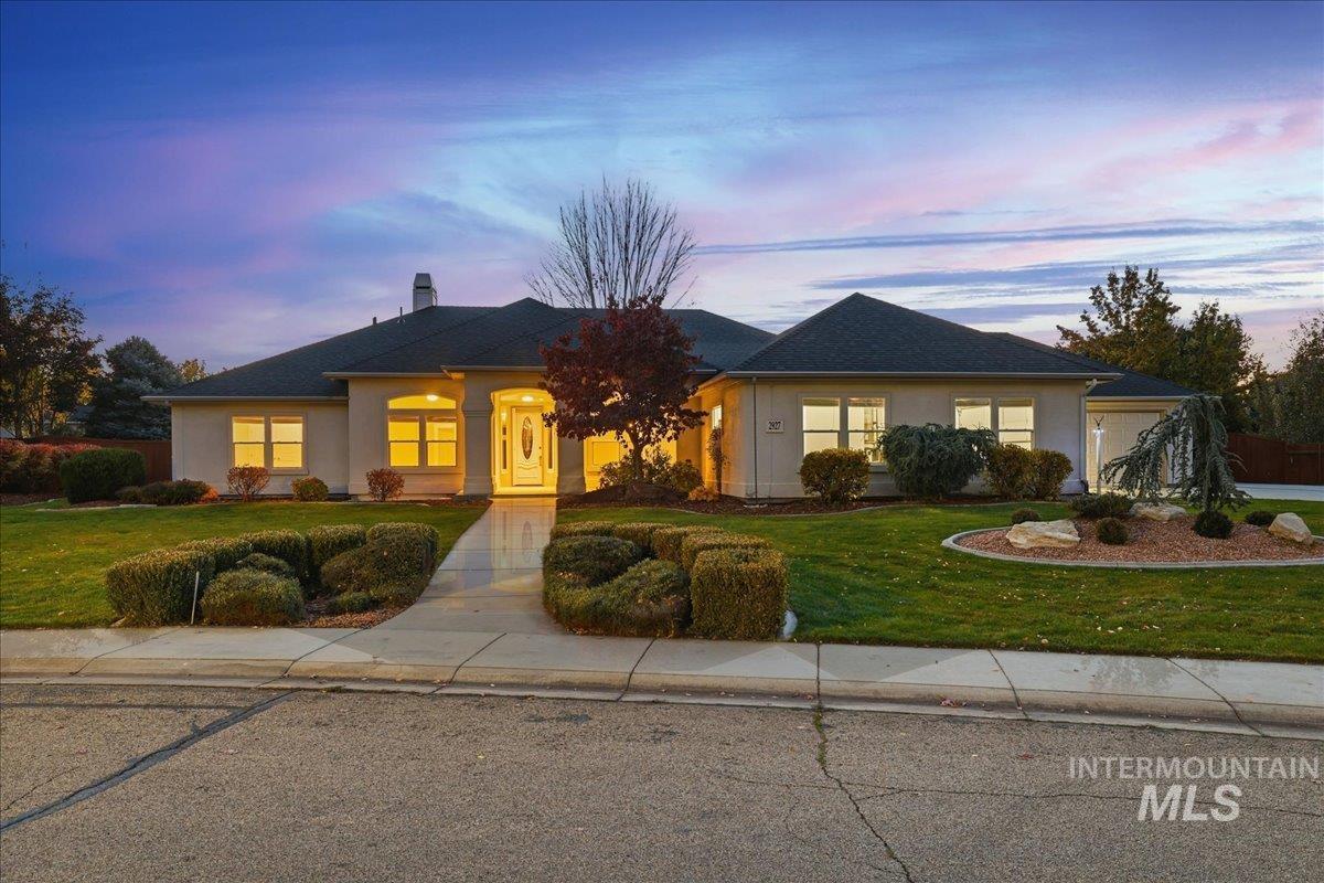 View of front of home with a front yard, a chimney, and stucco siding