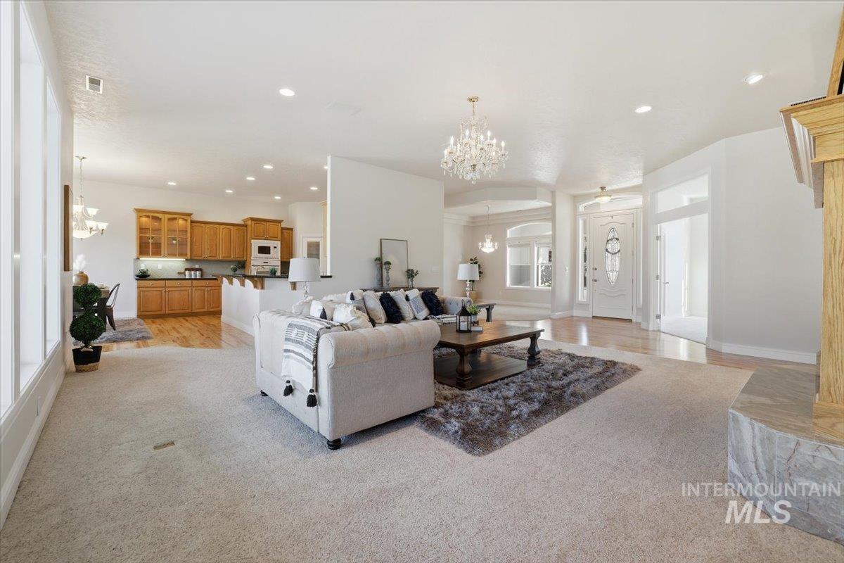 Living room featuring a chandelier, recessed lighting, and light wood-type flooring