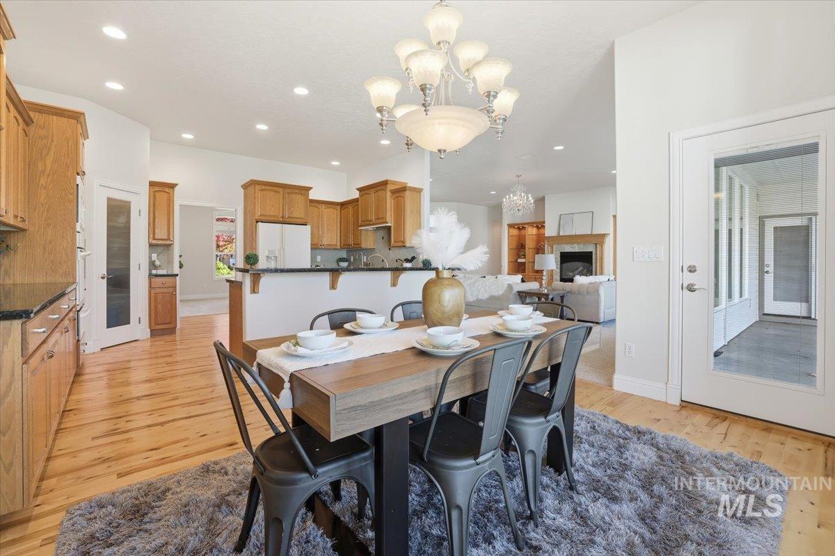 Dining area with a chandelier, light wood-style flooring, and recessed lighting