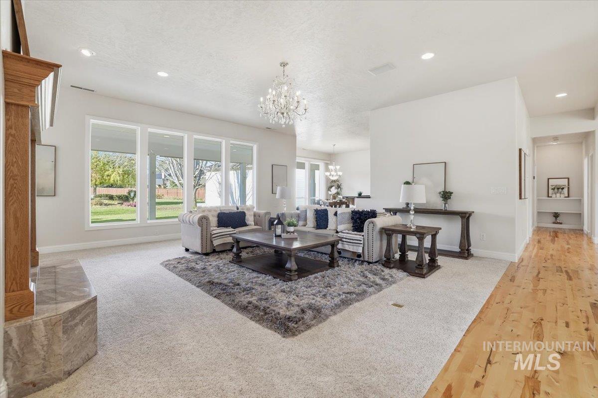 Living area featuring a chandelier, recessed lighting, light carpet, and a textured ceiling