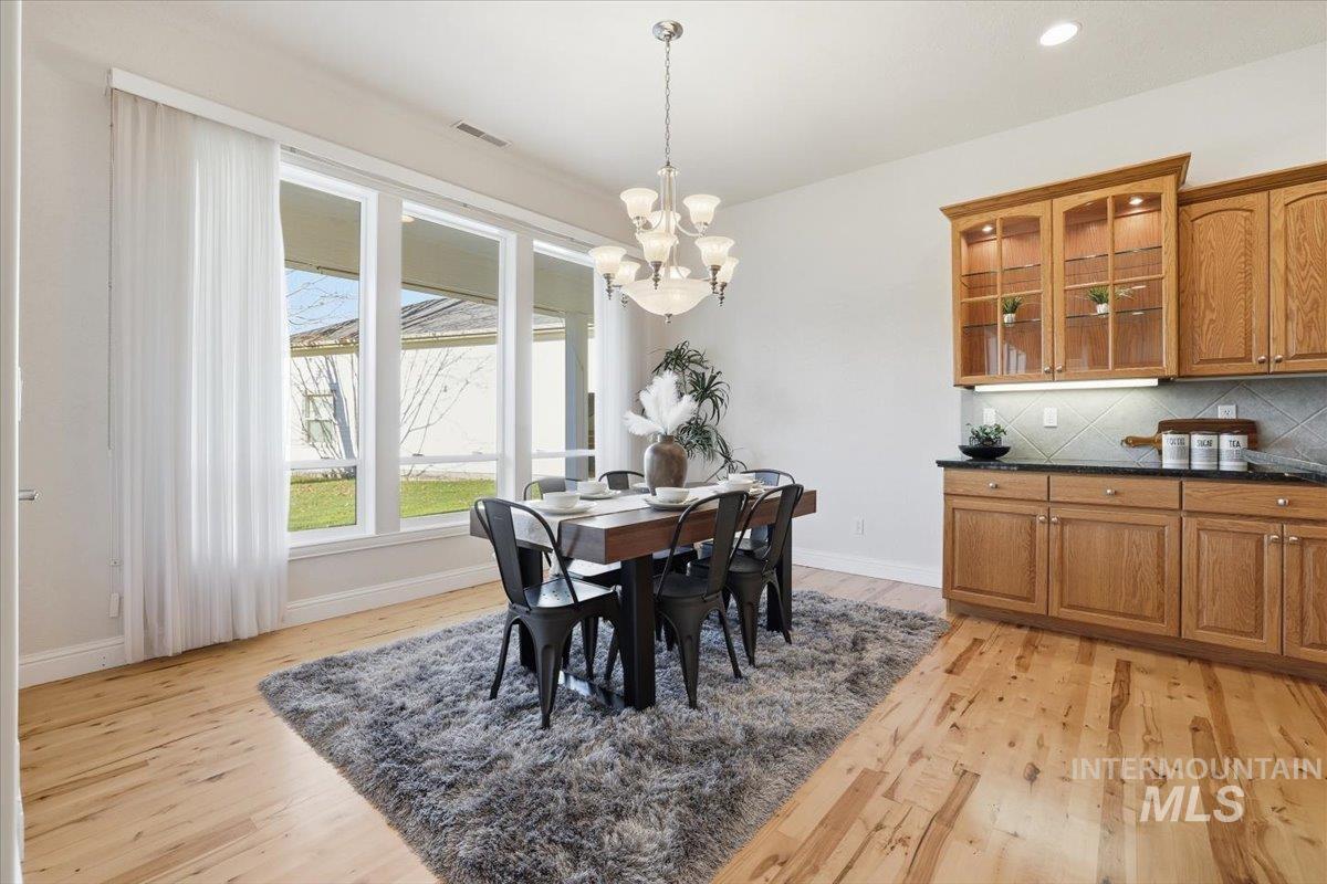 Dining room featuring light wood-type flooring, a chandelier, and recessed lighting