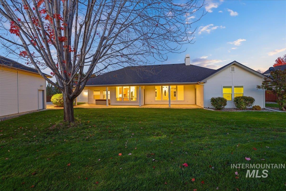 View of front of house with a chimney and a yard