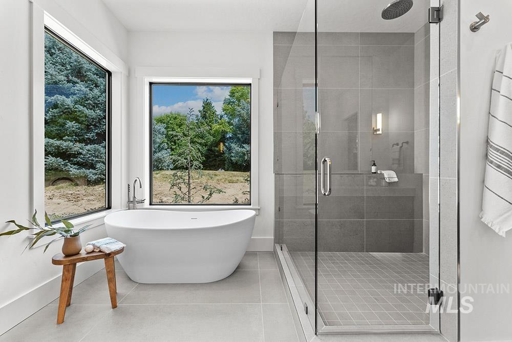 Full bath featuring a stall shower, a soaking tub, and tile patterned flooring