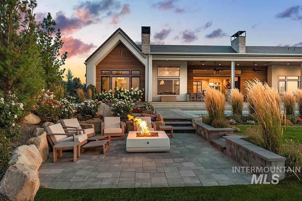 Rear view of property with a patio area, a chimney, and an outdoor fire pit