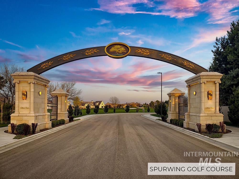 View of asphalt street featuring street lights, curbs, and sidewalks