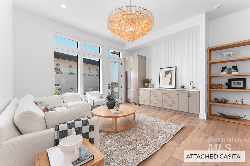 Living room featuring light wood finished floors, a chandelier, and recessed lighting