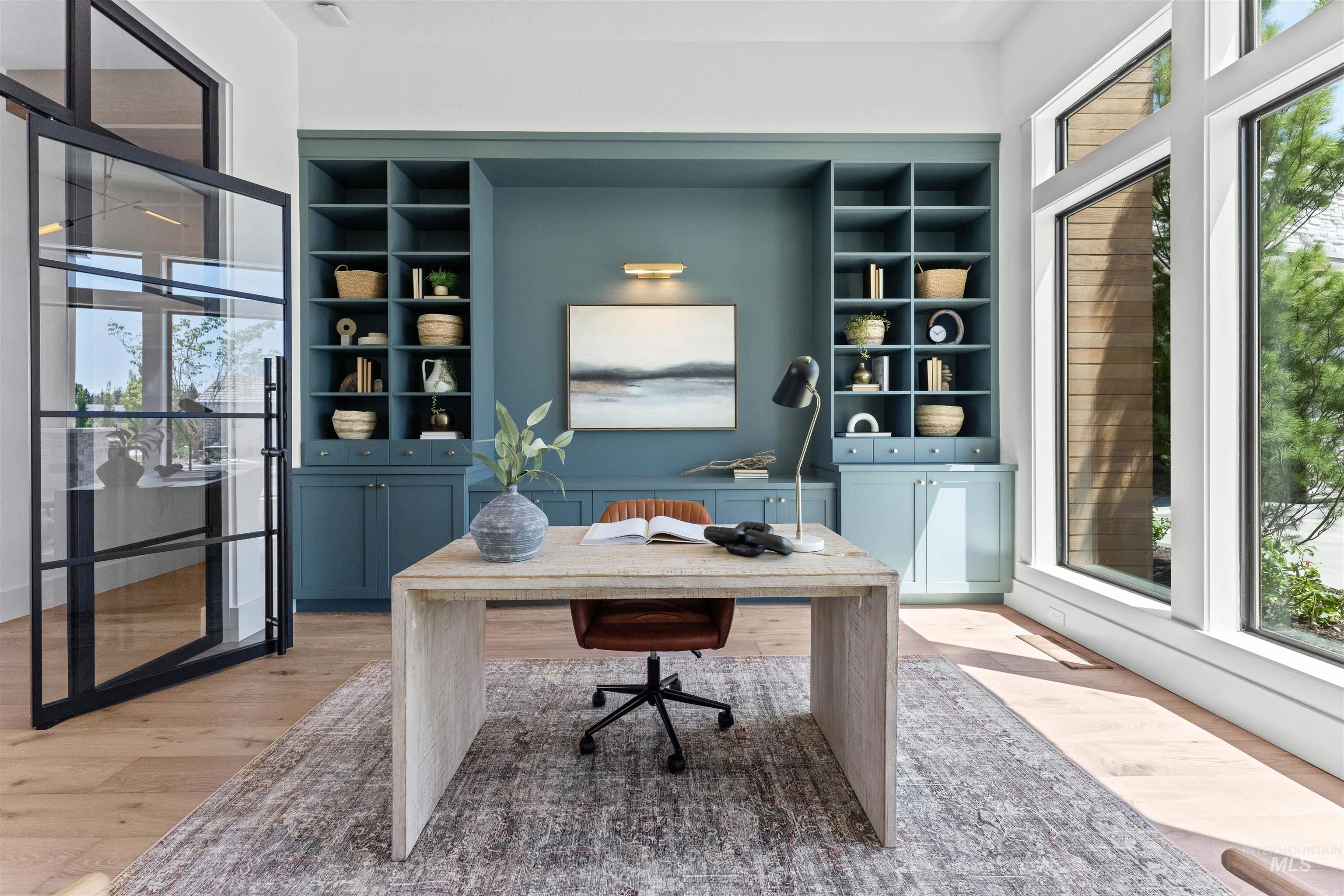 Office with light wood-type flooring and built in features