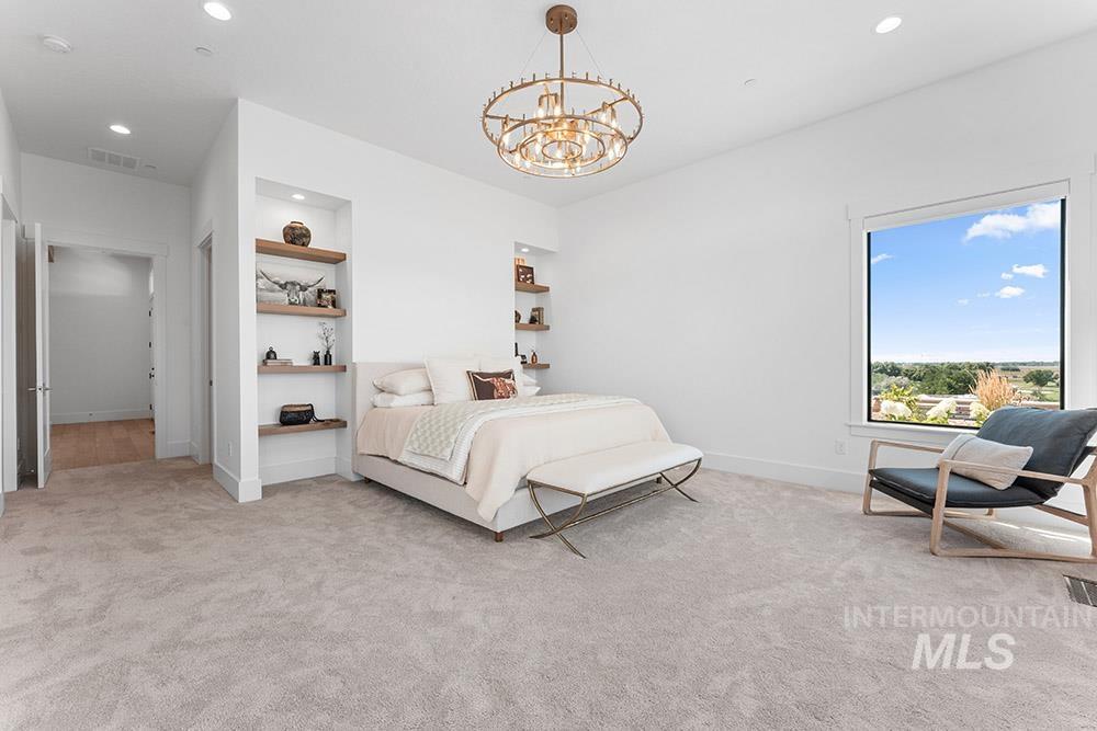 Carpeted bedroom featuring recessed lighting and a chandelier