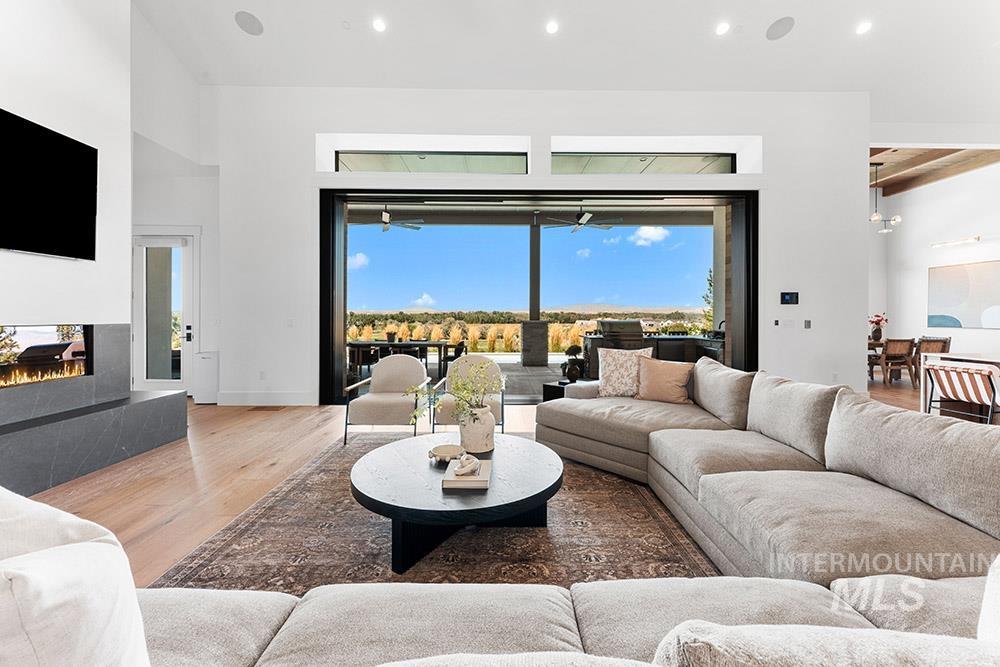 Living room featuring a multi sided fireplace, wood finished floors, and recessed lighting