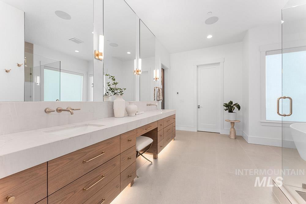 Bathroom featuring double vanity, a shower stall, a freestanding bath, and recessed lighting