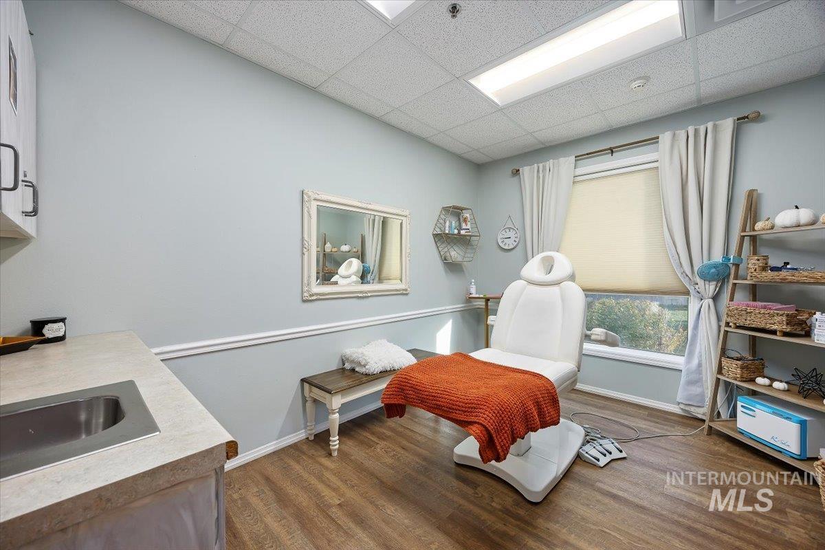 Sitting room featuring dark wood-style floors and a drop ceiling
