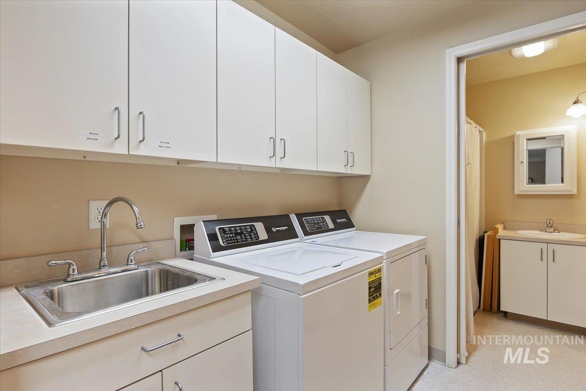 Washroom featuring washing machine and clothes dryer and cabinet space