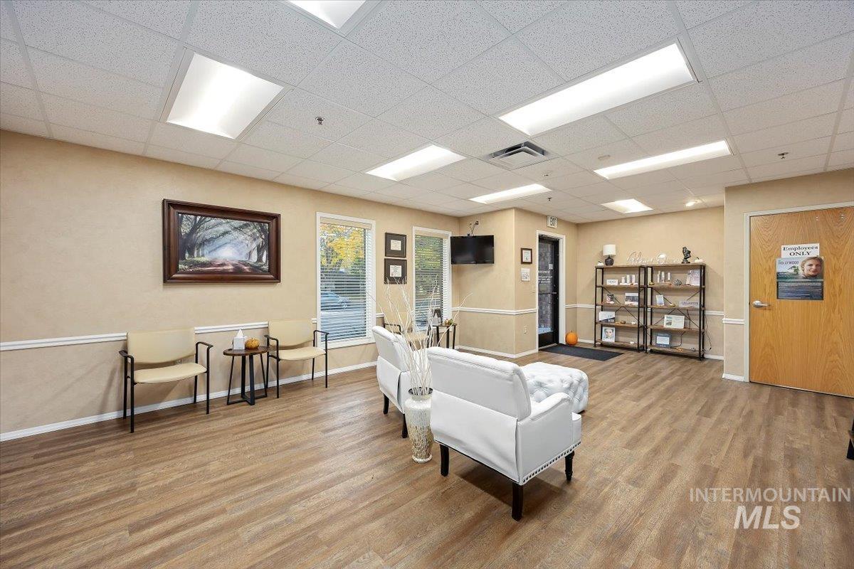 Living room with a paneled ceiling and wood finished floors