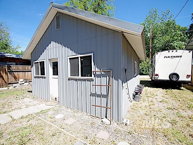 Freestanding accessory structure with vertical corrugated metal siding and a pitched roof