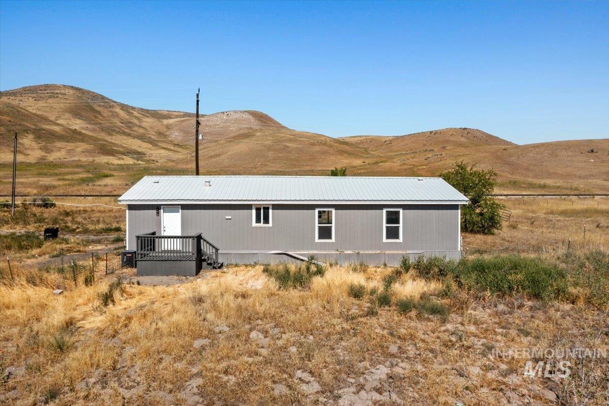 Rear view of house featuring a mountain view and a metal roof