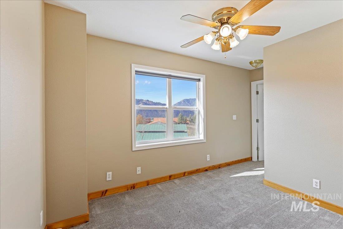 Unfurnished room featuring carpet and a ceiling fan