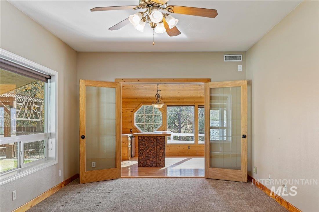 Empty room featuring french doors and carpet
