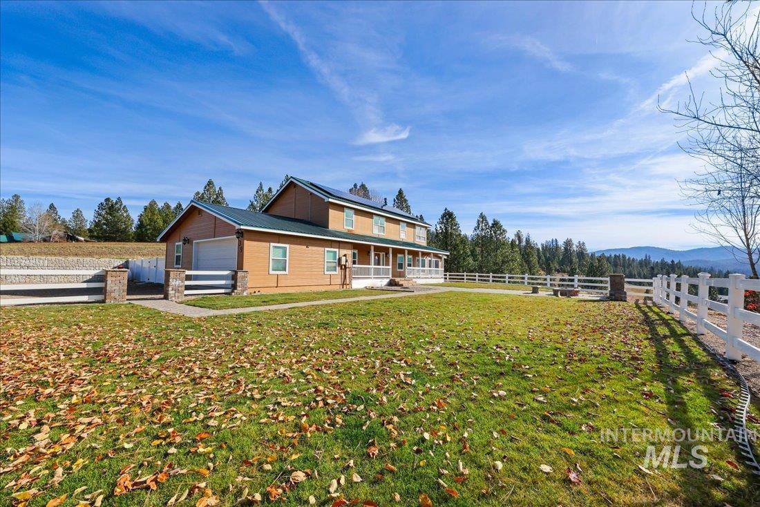 View of side of home featuring covered porch, a garage, and a metal roof