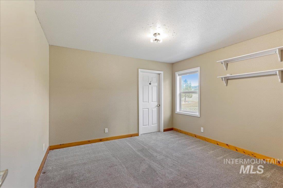 Unfurnished bedroom with a textured ceiling and carpet