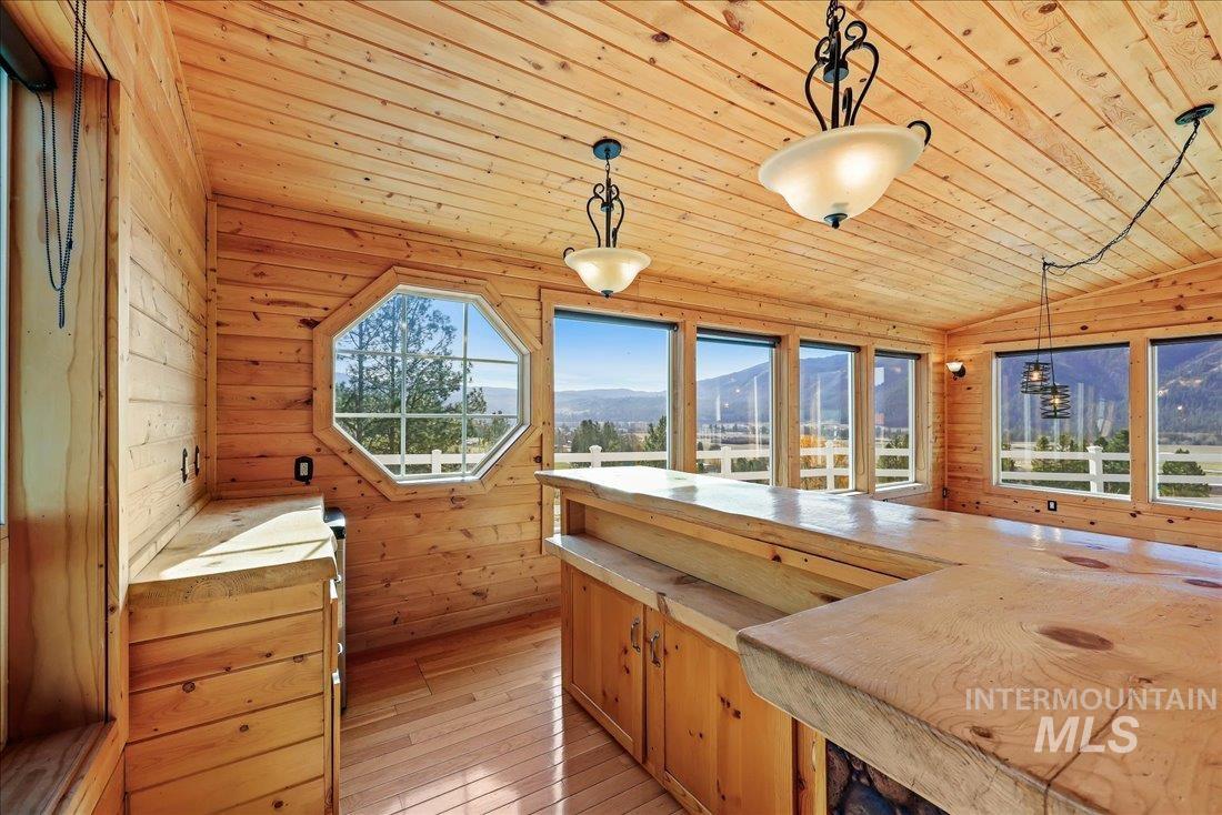 Kitchen featuring wooden walls, decorative light fixtures, light wood-type flooring, wooden ceiling, and a mountain view