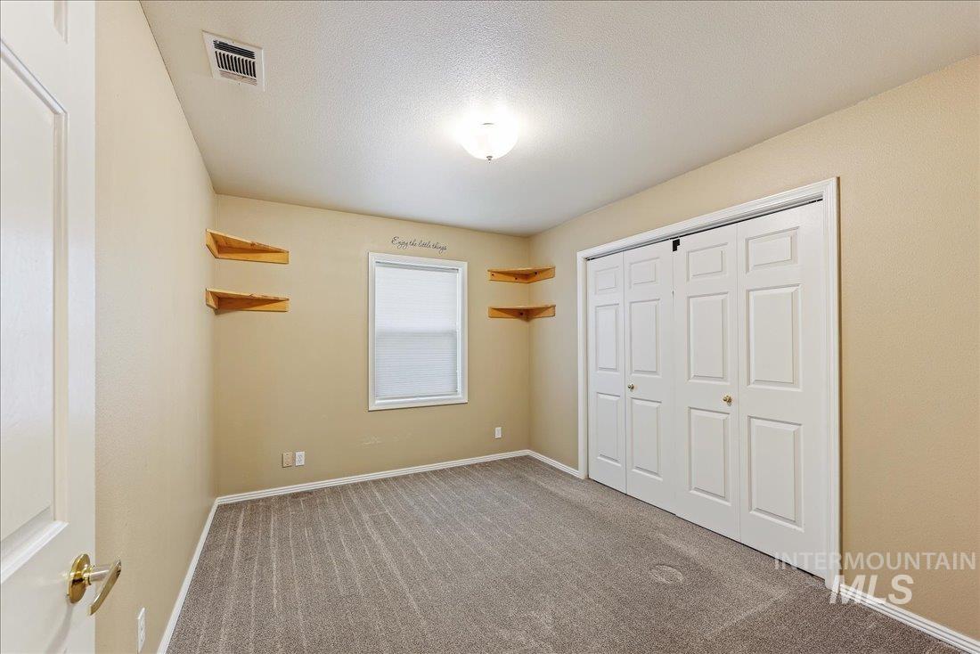 Unfurnished bedroom featuring carpet floors, a closet, and a textured ceiling