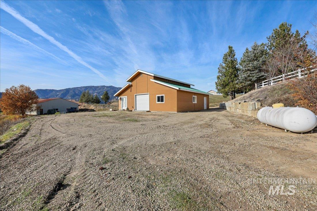 View of home's exterior featuring a mountain view, an outdoor structure, and a detached garage