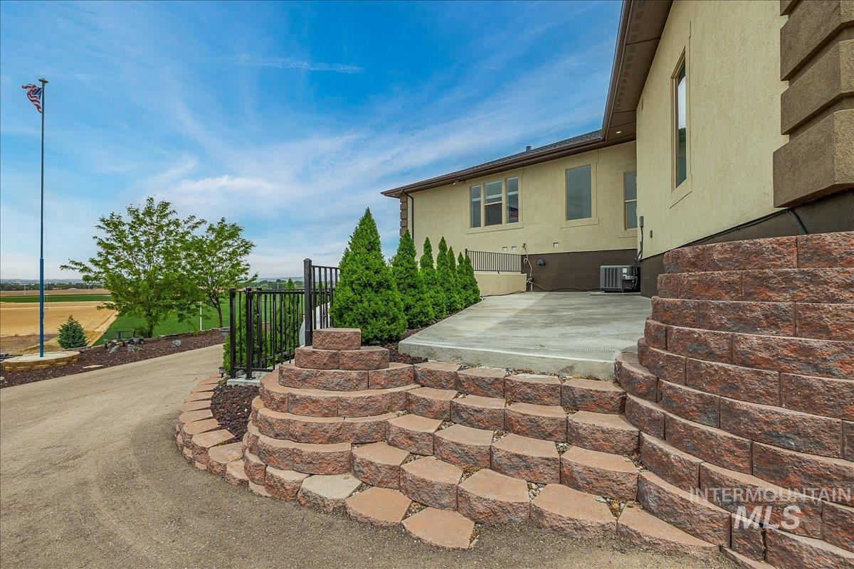 Exterior featuring a stucco facade and tiered stone retaining walls