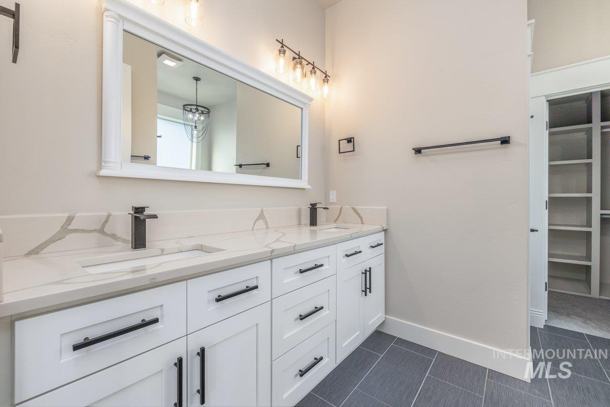 Full bathroom featuring double vanity and a walk in closet