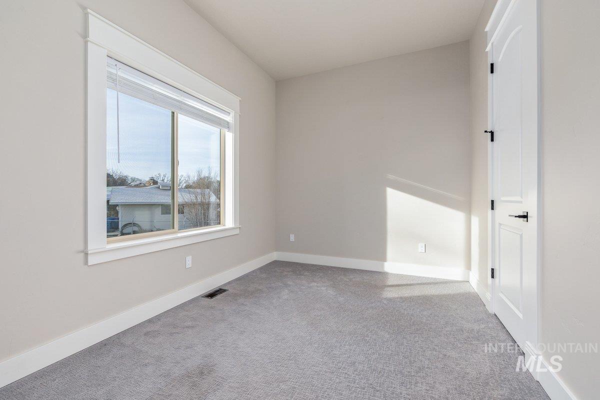 Spare room with light carpet and baseboards
