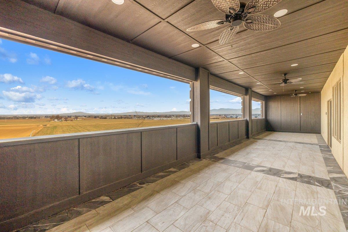 View of patio featuring ceiling fan and a mountain view