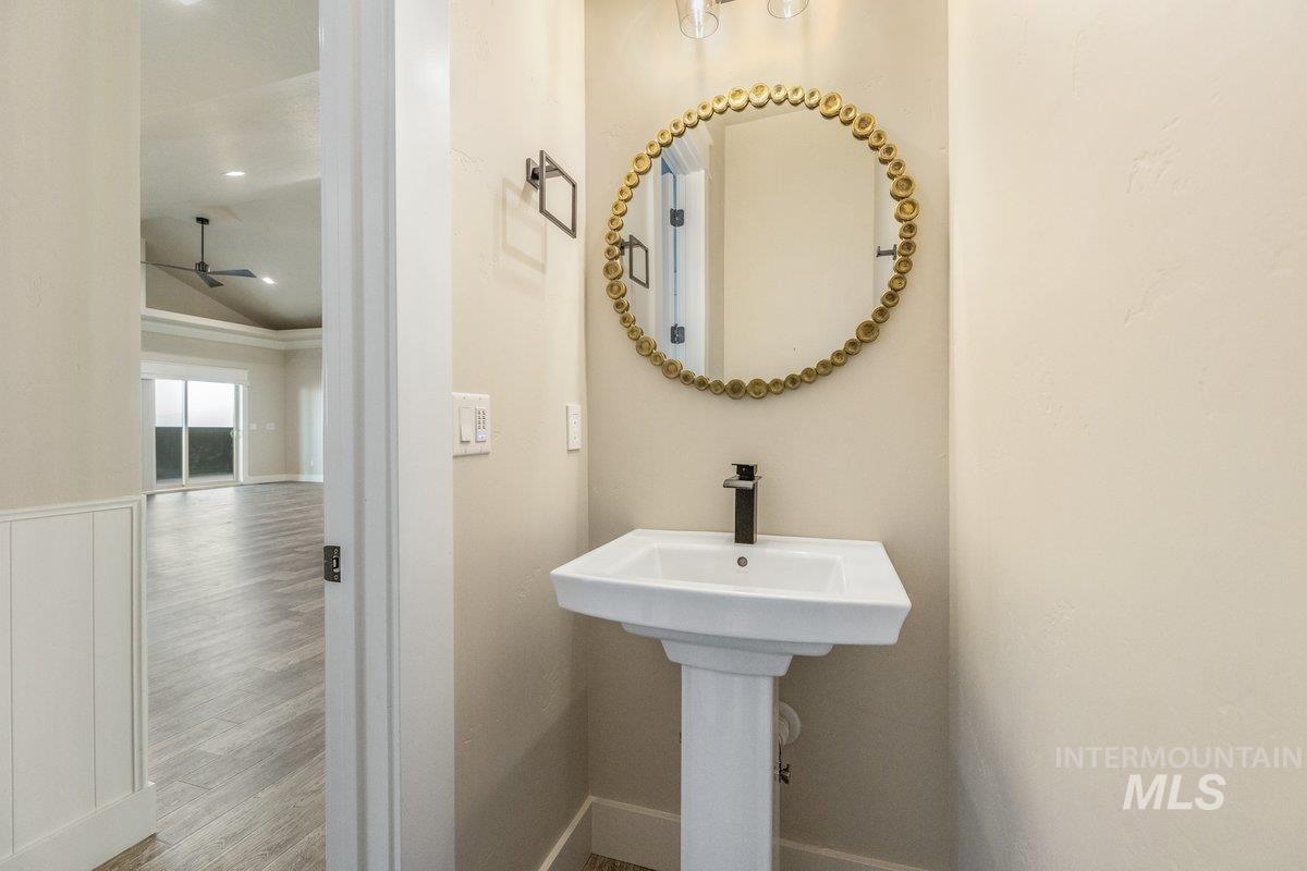 Bathroom featuring wood finished floors, a ceiling fan, lofted ceiling, and recessed lighting