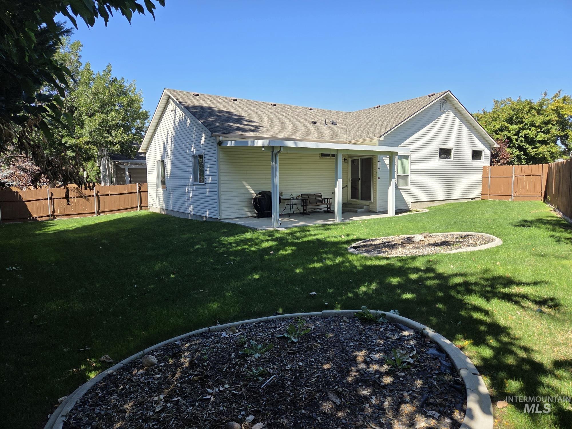 Back of property with a patio area, a fenced backyard, and a shingled roof